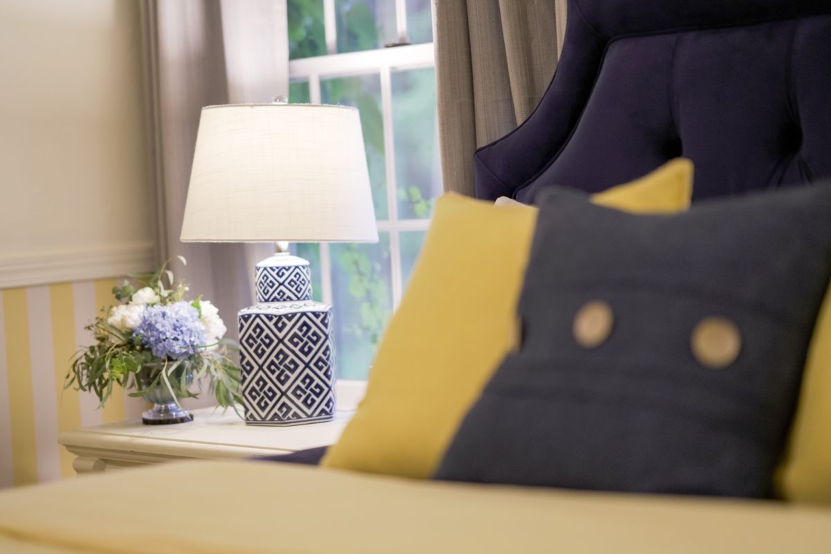 Swedish room with bed side table, lamp and garden views