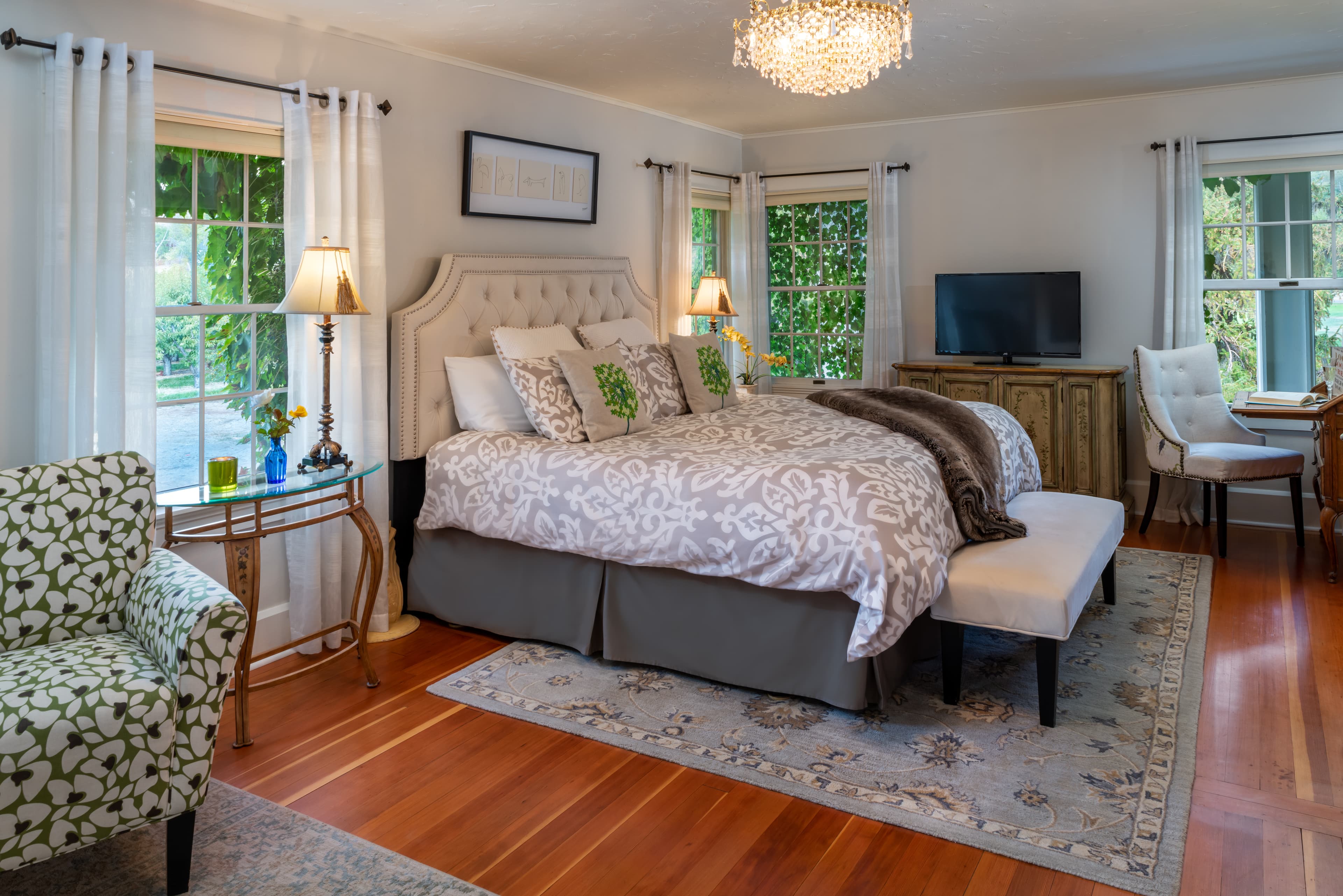 Garden Suite sitting area with green love seat, decorative armchairs and coffee table