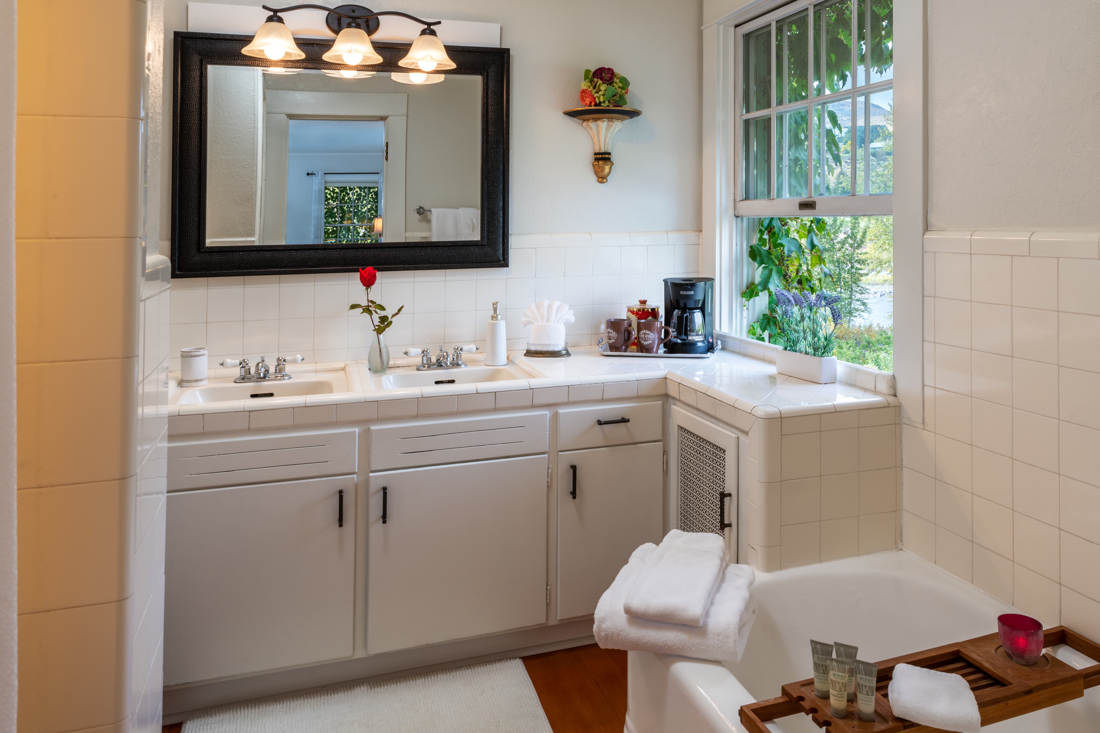 Garden Suite view into additional bedroom with twin bed, small chair, lamp and grey tones