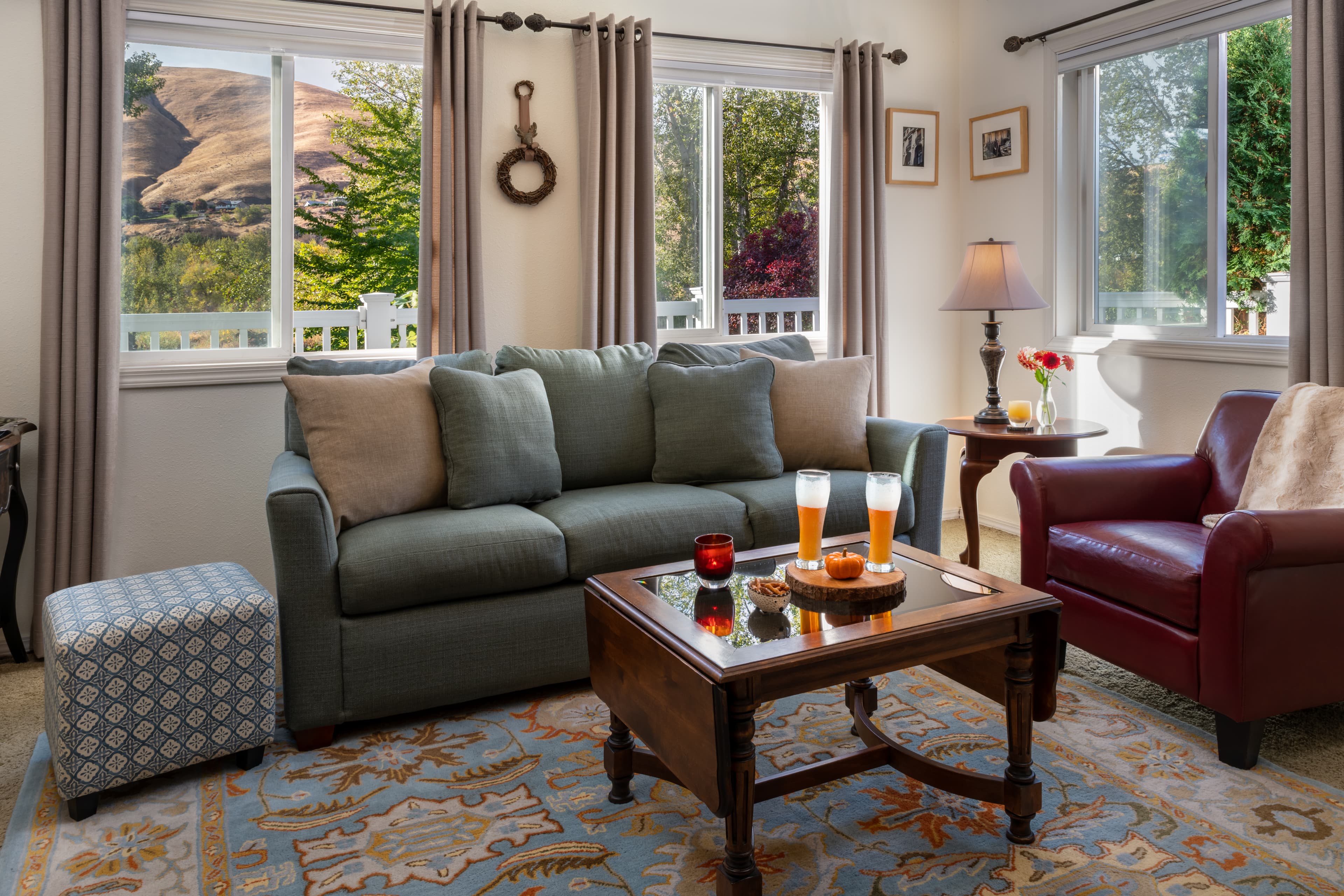 Orchard room sitting area with sleeper sofa, red leather armchair and coffee table