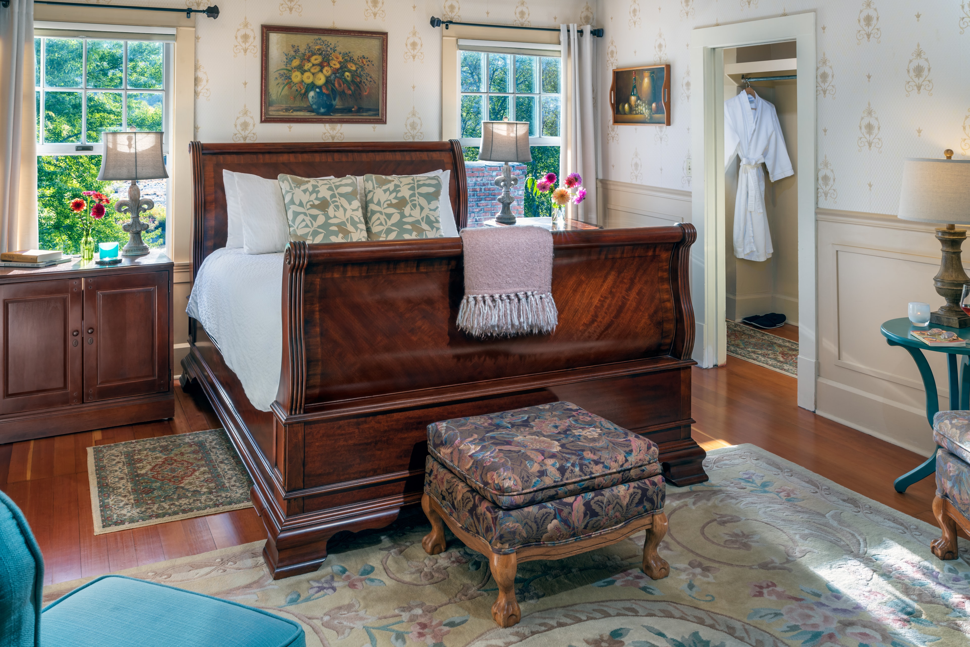 English room with queen bed, floral accents and bright windows